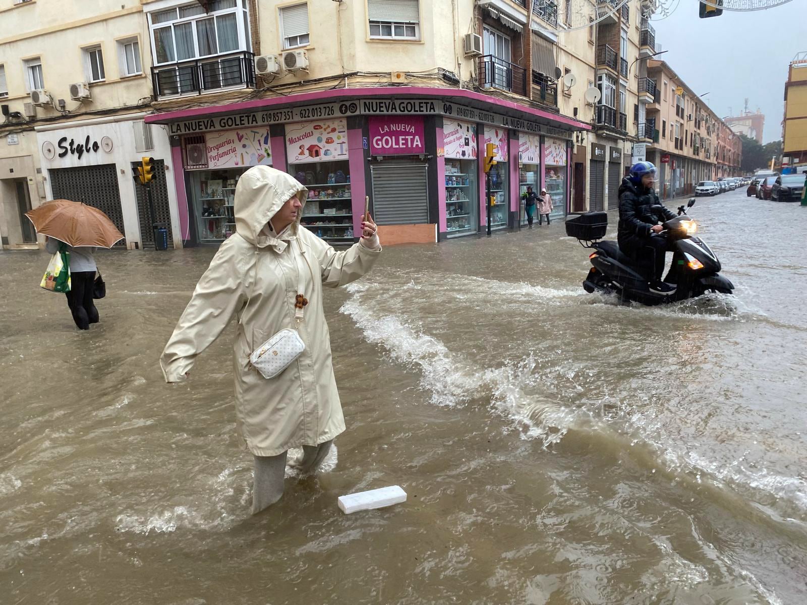 Una mujer hace fotos con el agua hasta las rodillas en Málaga donde las fuertes trombas de agua y granizo que se registran este miércoles han causado inundaciones y la acumulación de grandes balsas en algunas de las principales avenidas de todos los distritos de la ciudad.EFE/María Alonso