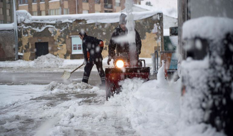Varias personas limpian de nieve una calle de la localidad cántabra de Reinosa, cuya comunidad se encuentra en alerta amarilla por nieve después de haber estado en los últimos días en alerta roja.