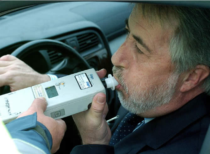 Un hombre realiza un test de alcoholemia.