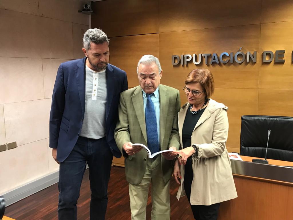 Ángel Garcés, el autor, junto con Alberto Sabio y Maribel de Pablo, hojeando el libro