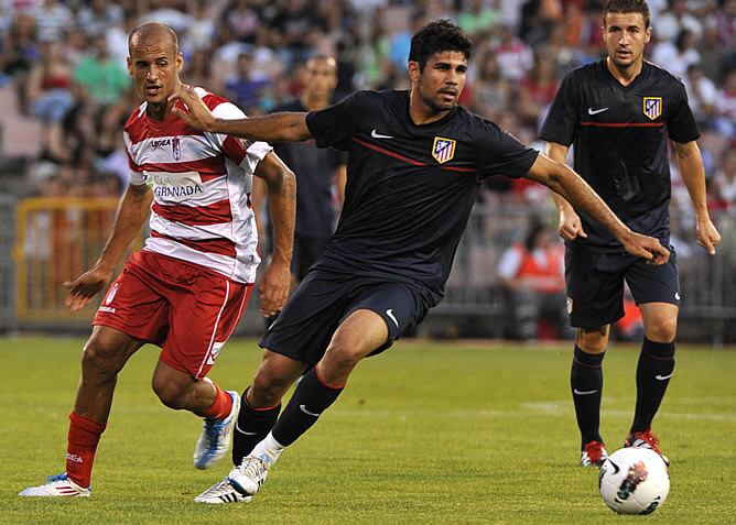 El delantero brasileño del Atlético de Madrid Diego Costa intenta controlar el balón durante el partido de pretemporada frente al Granada CF que ambos equipos han disputado en el estadio de Los Cármenes