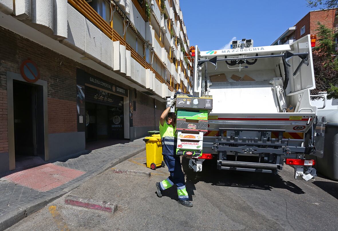 Los operarios recogiendo el papel y cartón