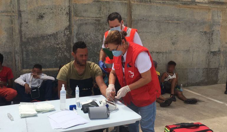 Voluntarios de Cruz Roja atienden a un inmigrantes llegado en patera a la Vila Joiosa