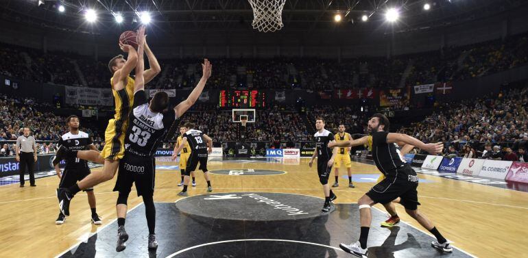 El alero estadounidense del Iberostar Tenerife Tim Abromaitis (i) lanza a canasta ante el alero español del Dominion Bilbao Basket Álex Suárez (2i), durante el partido de la jornada 14 de liga ACB que ambos conjuntos han disputado hoy en Bilbao