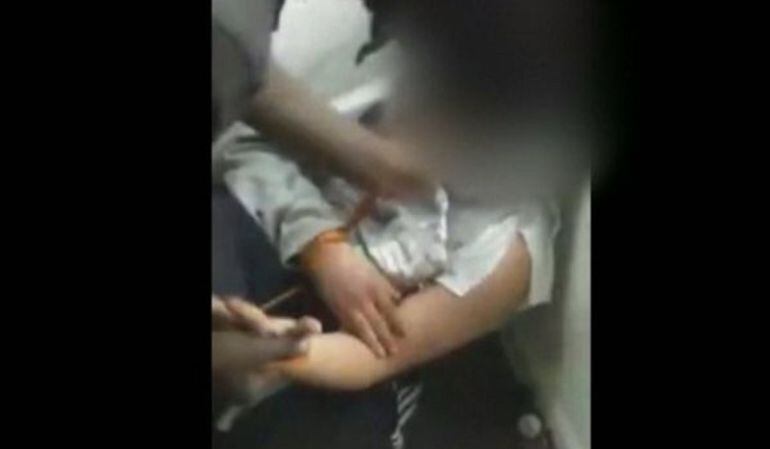 Fragmento del vídeo en el que cuatro individuos agreden a un joven.