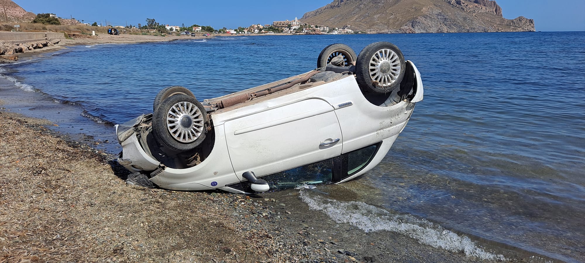 El vehículo ha volcado y ha quedado junto al mar