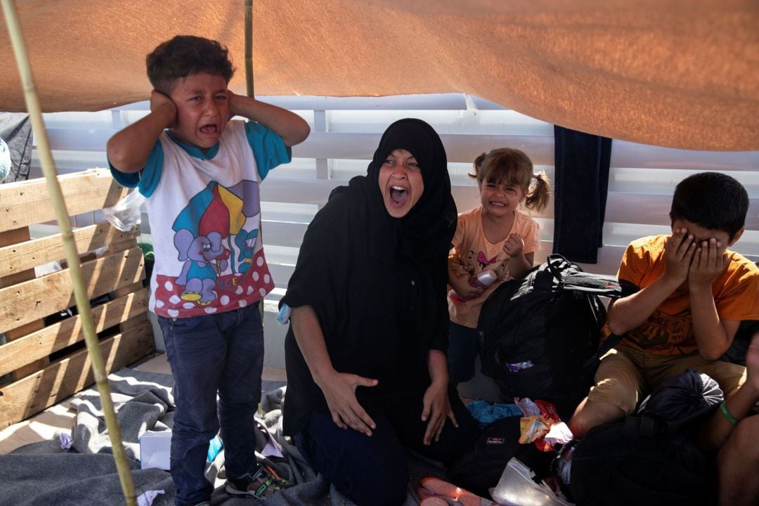 Woman and children react as refugees and migrants from the destroyed camp of Moria flee clash with riot police, on the island of Lesbos, Greece, 12, 2020. REUTERS Alkis Konstantinidis