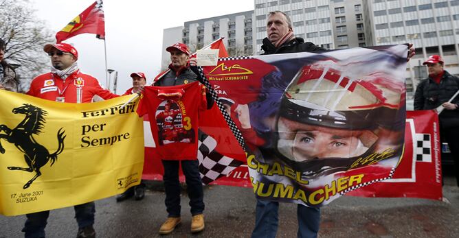 Varios aficionados muestran su apoyo al campeón a las puertas del hospital en el que está ingresado tras el accidente de esquí que sufrió en los Alpes franceses.