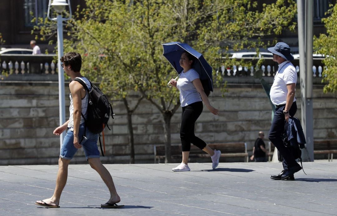 Una mujer se protege con un paraguas del calor en Bilbao en una imagen de archivo