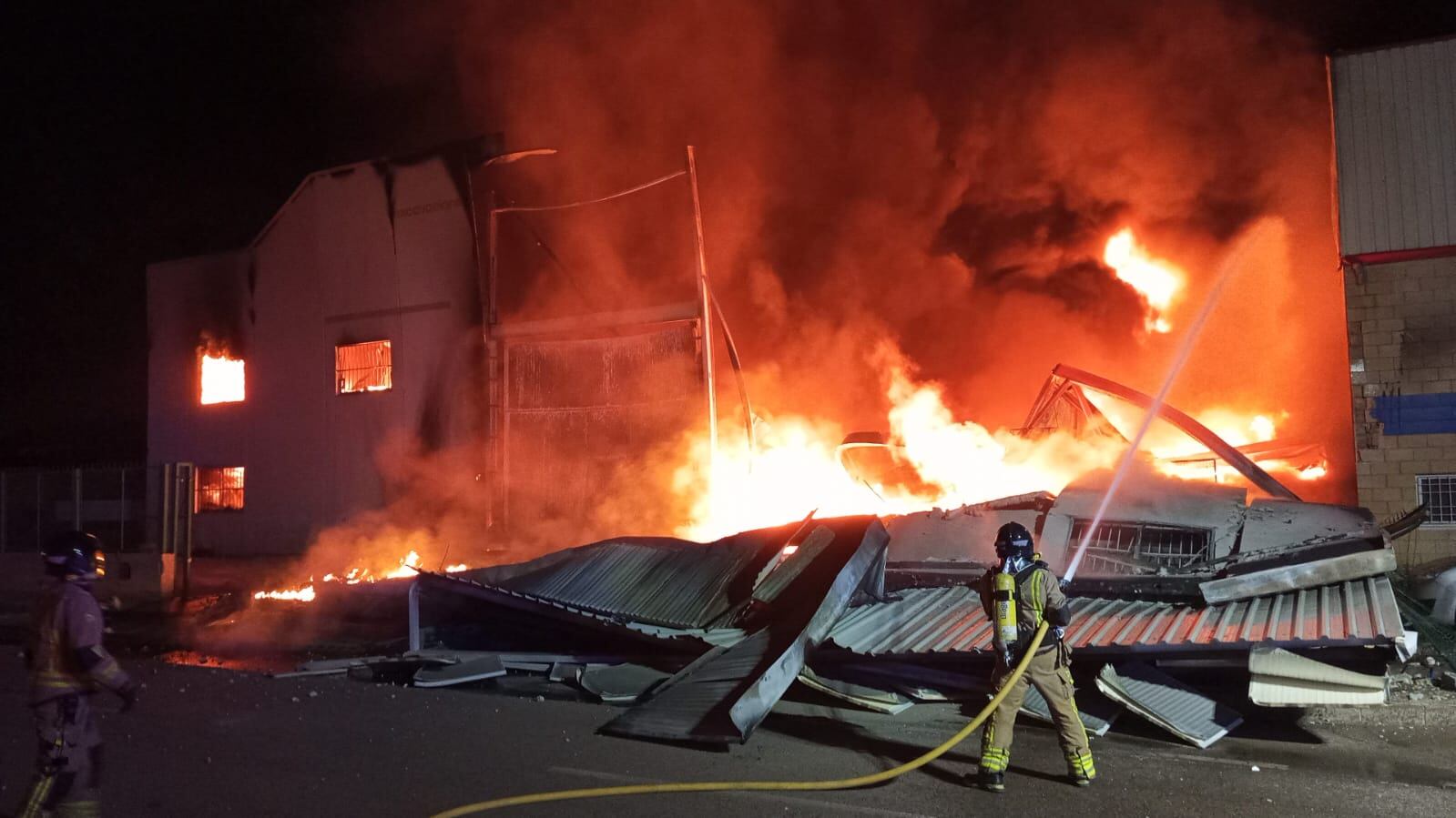 Bomberos apagando  el incendio producido en una de las naves afectadas en el Polígono Industrial de Puerto Lumbreras.