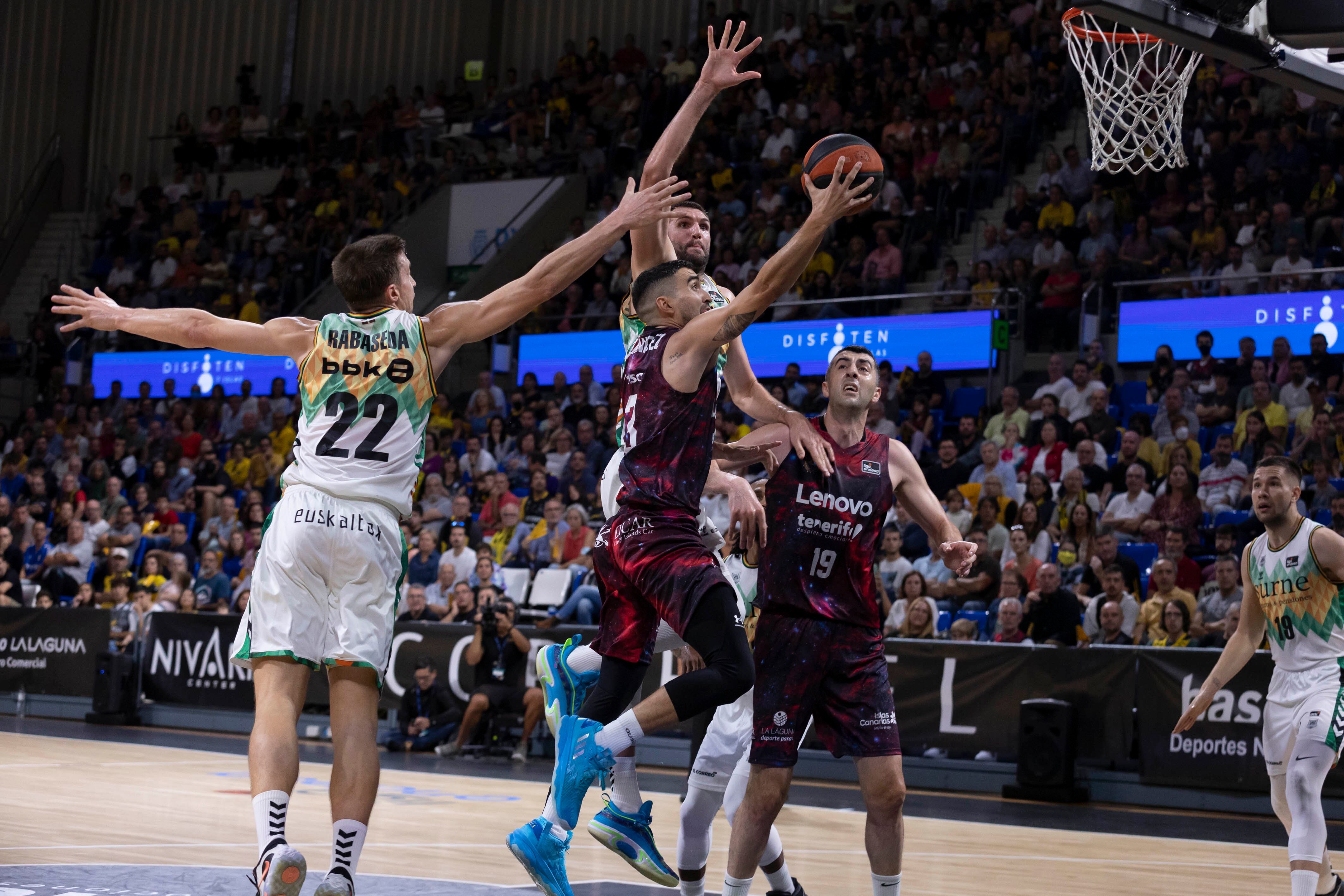 El jugador del Lenovo Tenerife, Jaime Fernández, intenta encestar ante las presencia de su compañero, Shermadini, (d) y los jugadores del Surne Bilbao, Rabaseda y Jeff Withey