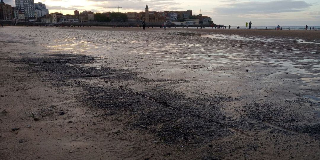 Manchas de carbón en el arenal de San Lorenzo.