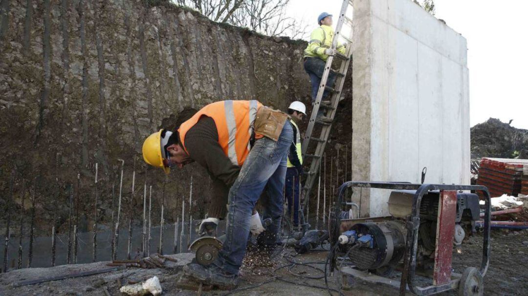 Varios operarios trabajan juntos en una obra.