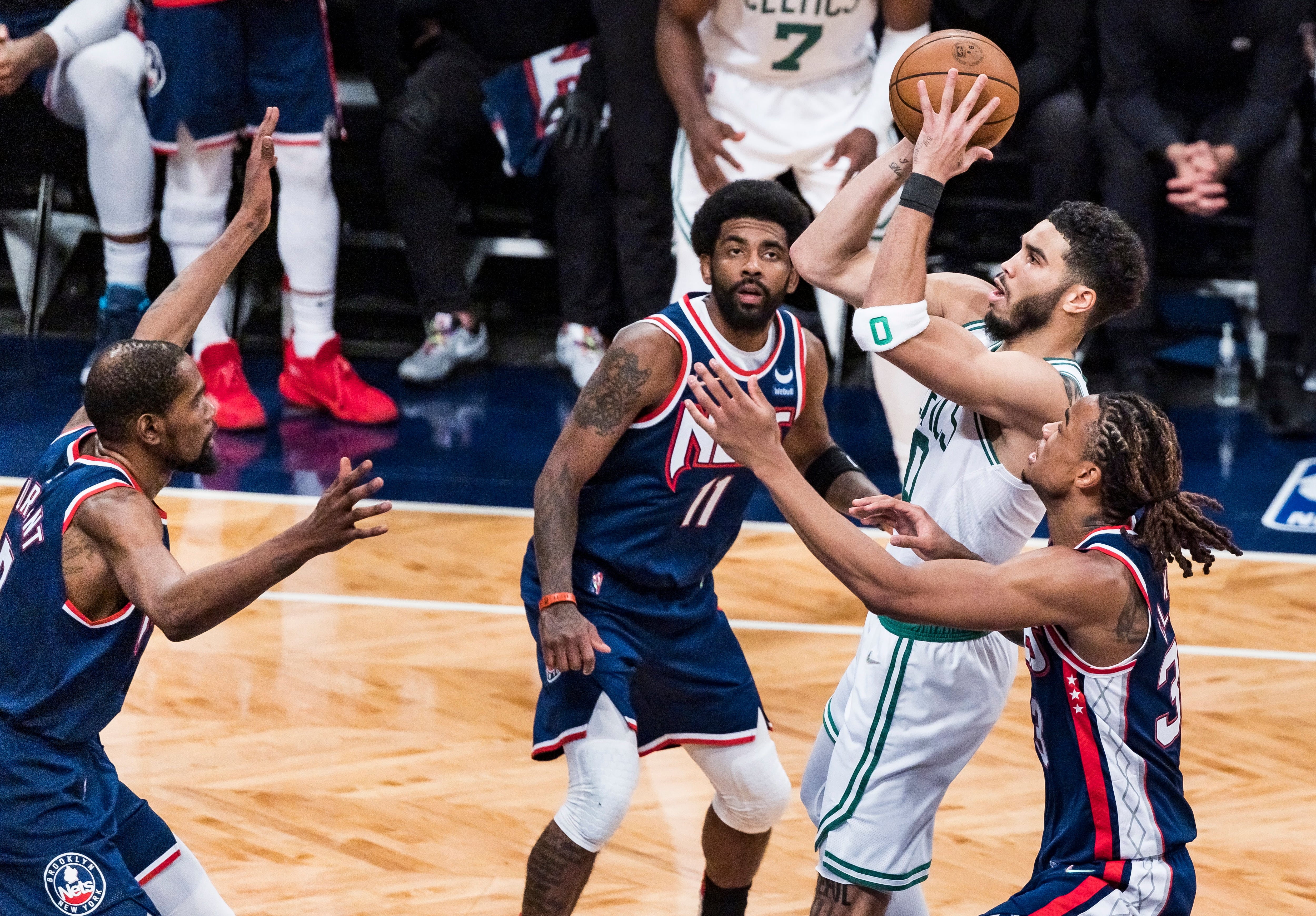 Jayson Tatum, de los Celtics, lanza a canasta ante la mirada de Nic Claxton, Kyrie Irving y Kevin Durant, de los Nets