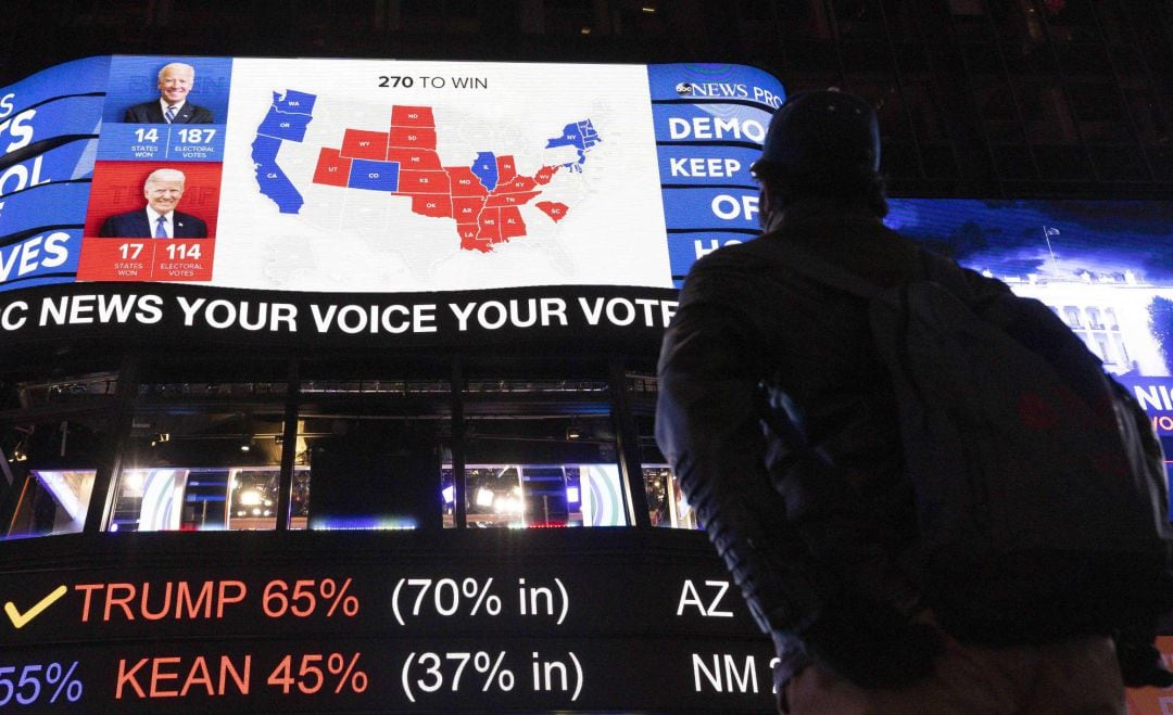 Personas en Times Square en Nueva York comprobando los resultados de las elecciones