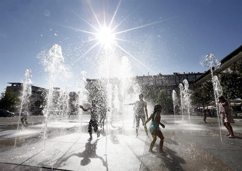 Niños refrescándose en una fuente de Madrid