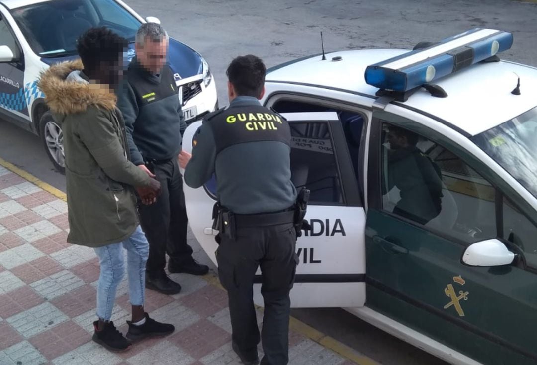 La Guardia Civil introduce al detenido en un coche patrulla.