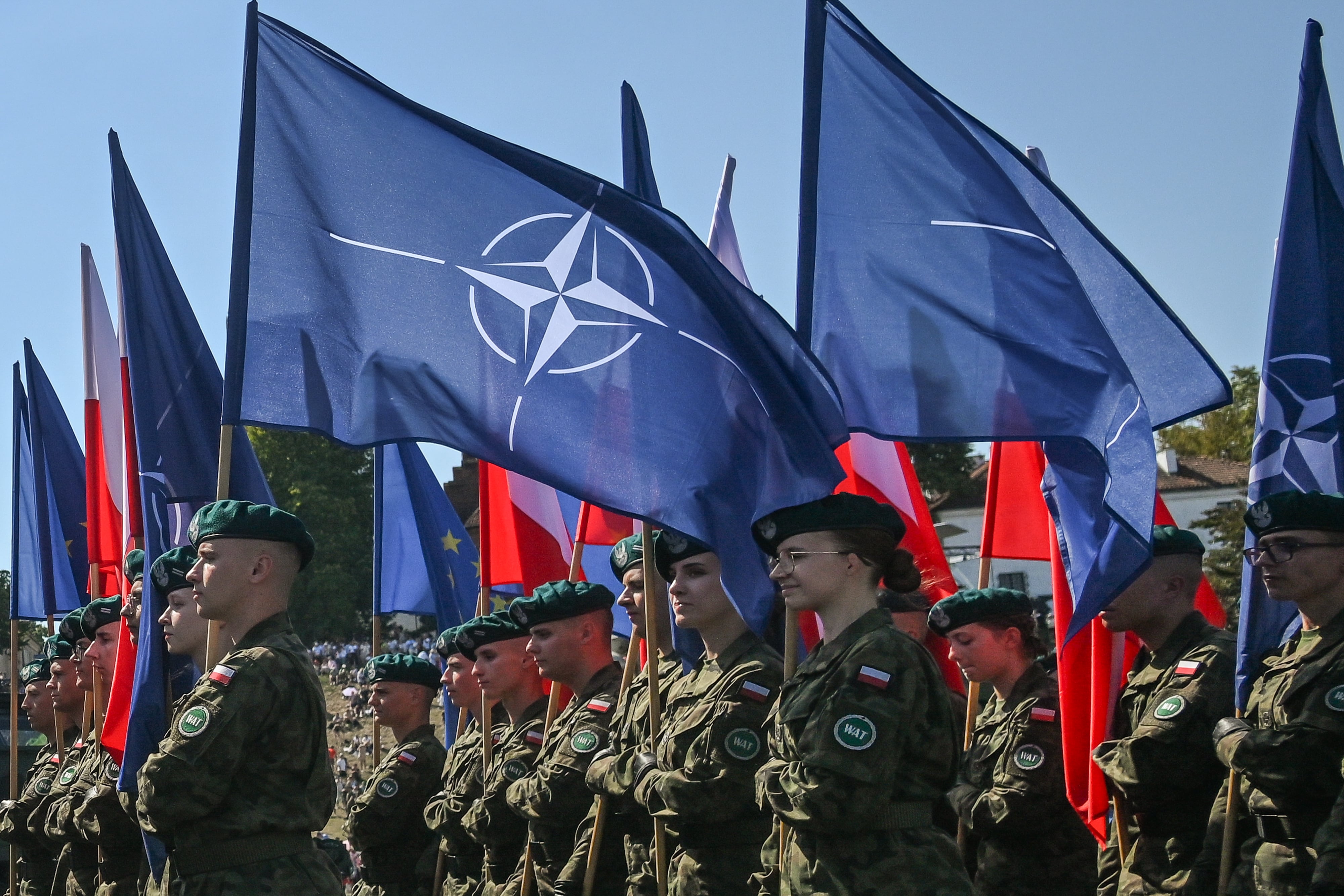 Soldados de Polonia portan banderas de la OTAN y de su país durante un desfile el pasado 15 de agosto