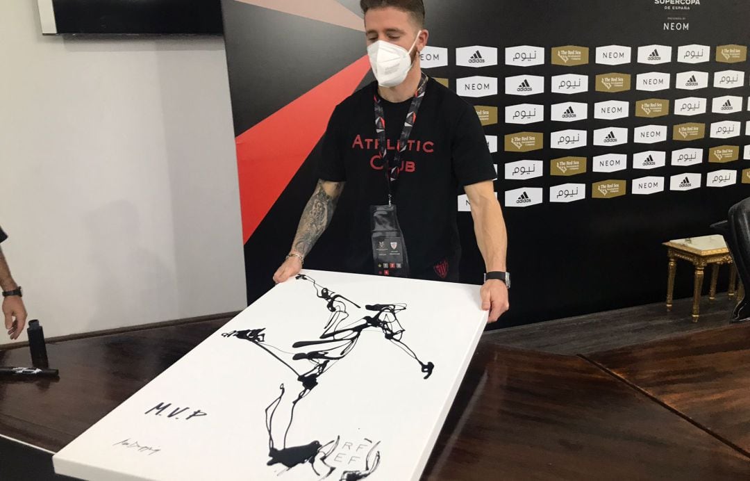 Iker Muniain muestra el retrato con el que han reconocido su actuación en el partido frente al Atlético de Madrid