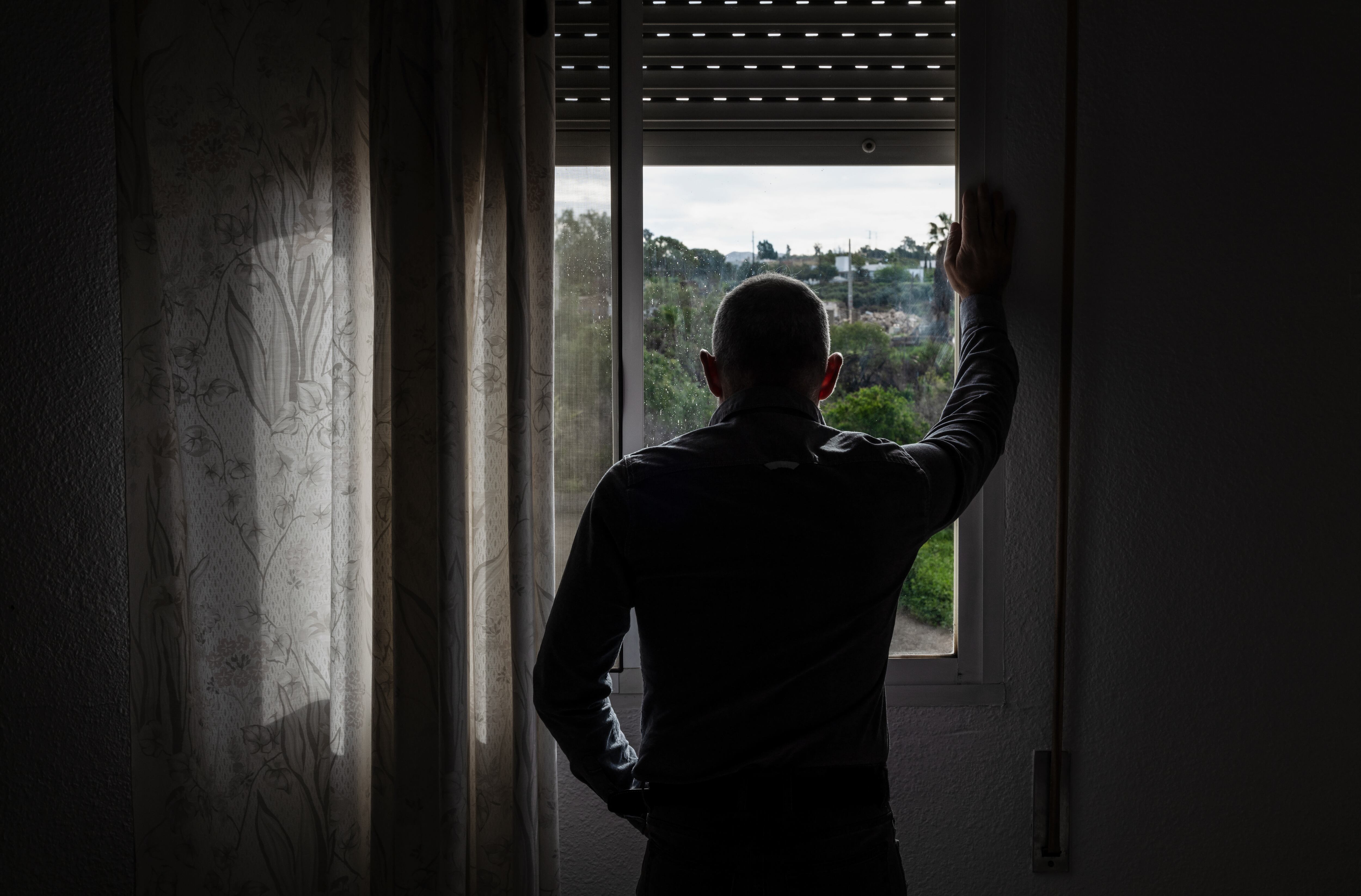 Hombre mirando por la ventana