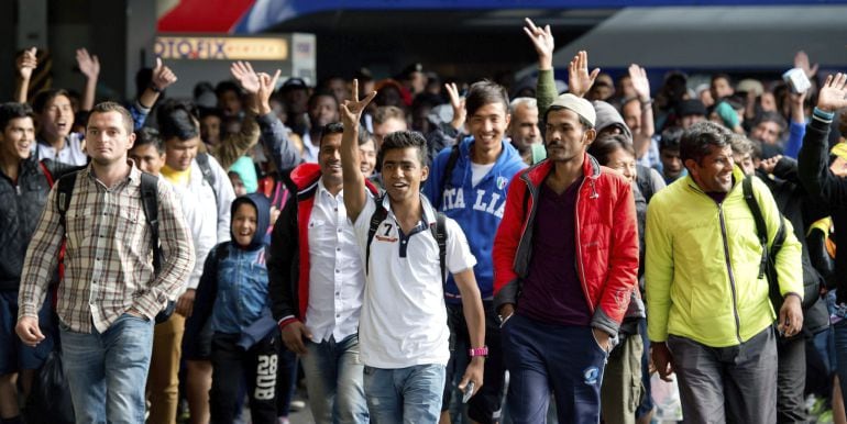 -FOTODELDIA- MUNICH, 06/09/2015.- Varios refugiados saludan a su llegada a la estación de tren de Munich, donde han llegado hoy cerca de 5.000. La mitad de los refugiados que han llegado a Múnich serán repartidos entre otros estados de Alemania, mientras 