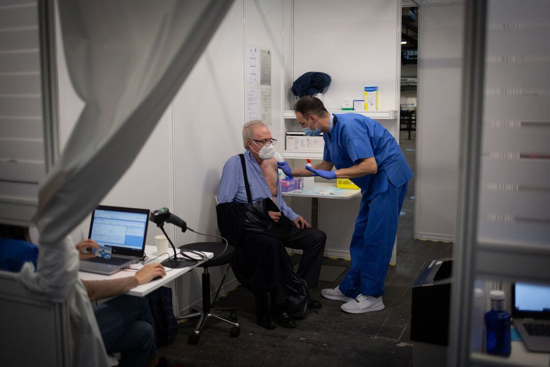 Un sanitario administra una vacuna de la COVID-19 desde el recinto de Fira Barcelona en el que este lunes se ha realizado una prueba piloto de la vacunación masiva.