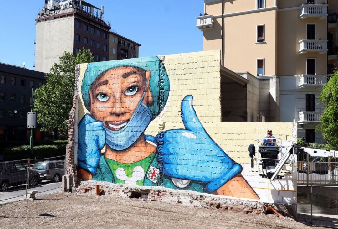 Un mural urbano que retrata a una sanitaria con mascarilla en las inmediaciones del Hospital San Luca en Milán