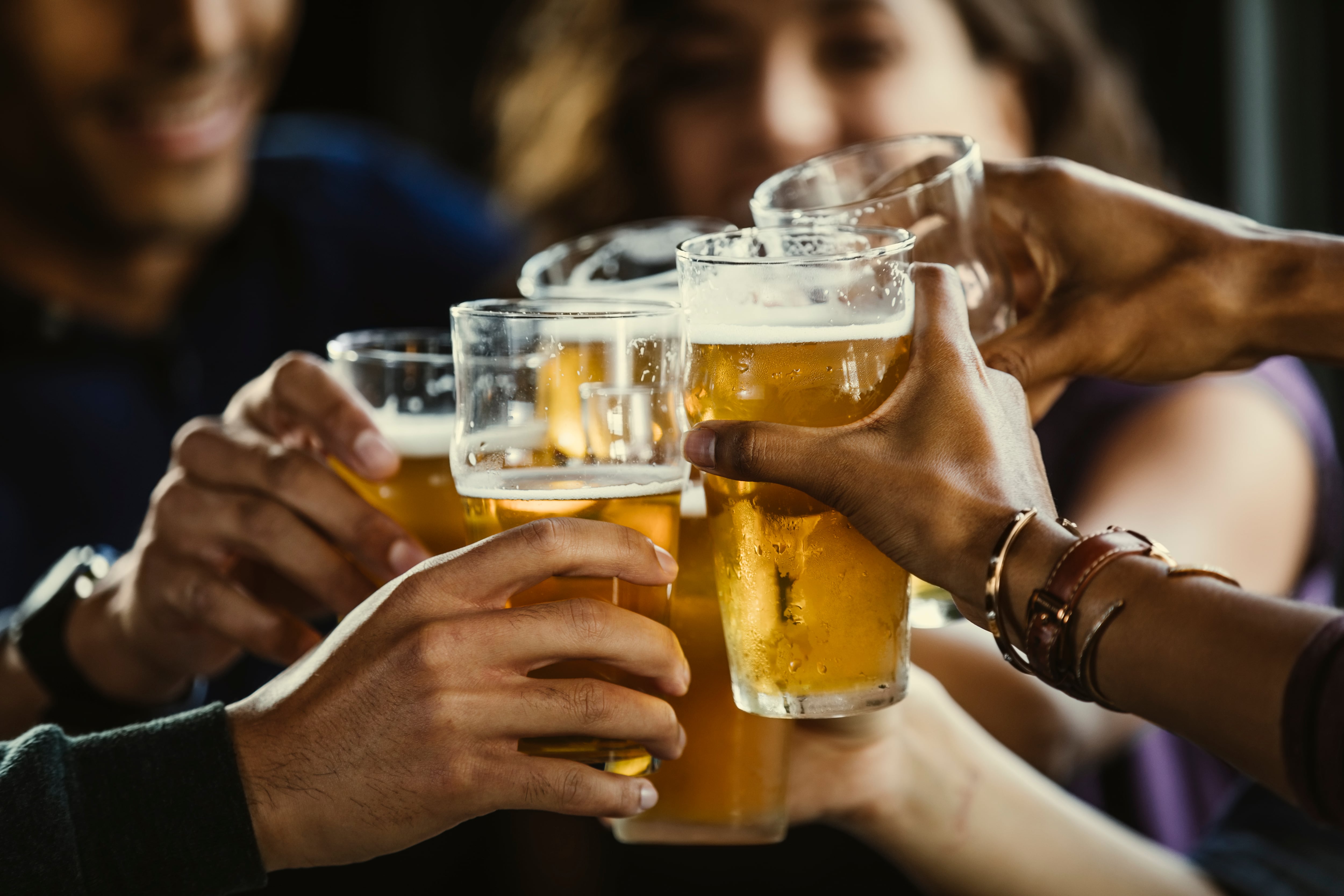 Amigos brindan con un vaso de cerveza