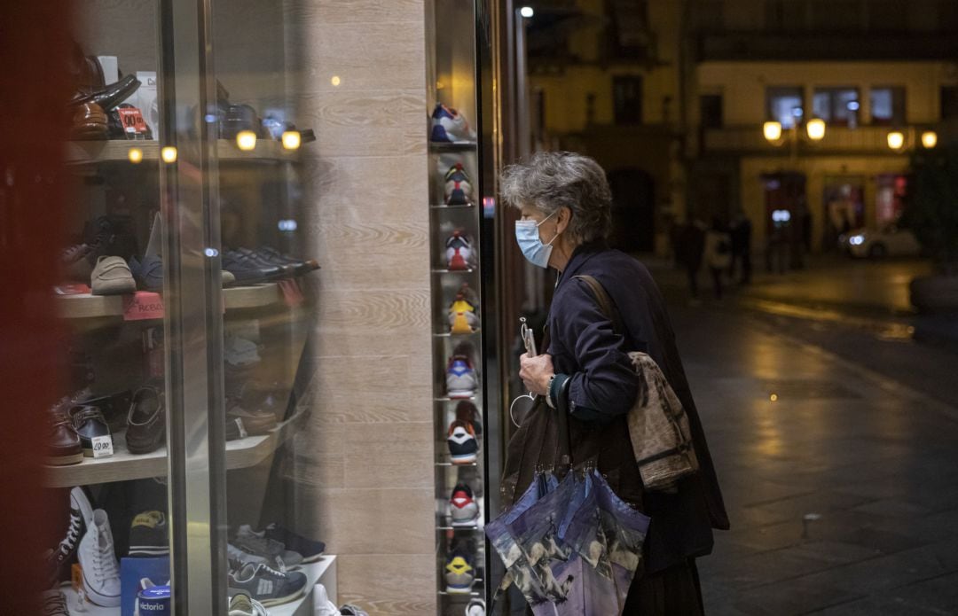 Una persona observa el escaparate de un comercio