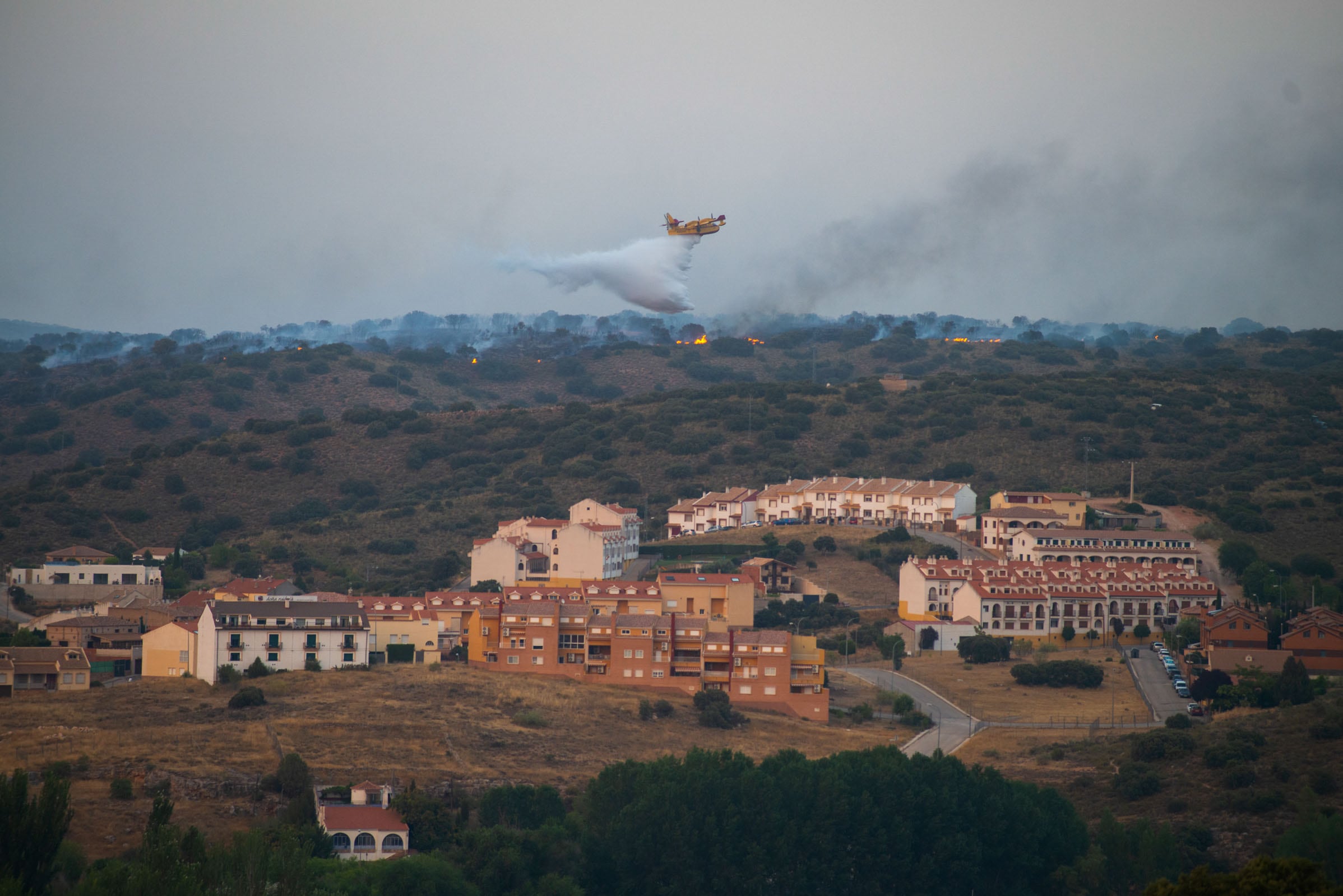 RUIDERA (CIUDAD REAL), 25/07/2022.- Efectivos del Servicio de Extinción de Incendios de Castilla-La Mancha (Infocam) luchan este lunes para evitar que el incendio forestal que se encuentra activo en el Parque Natural de Las Lagunas de Ruidera, en la provincia de Ciudad Real, pueda afectar a la urbanización &quot;Los Villares&quot;. EFE/Jesús Monroy
