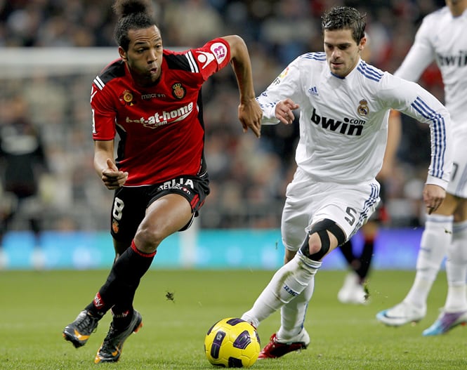 El mediocentro argentino del Real Madrid Fernando Gago (d) pugna por el balón con el delantero del RCD Mallorca Emilio Nsue durante el partido correspondiente a la vigésima jornada del Campeonato Nacional de Liga de Primera División que enfrenta esta tard