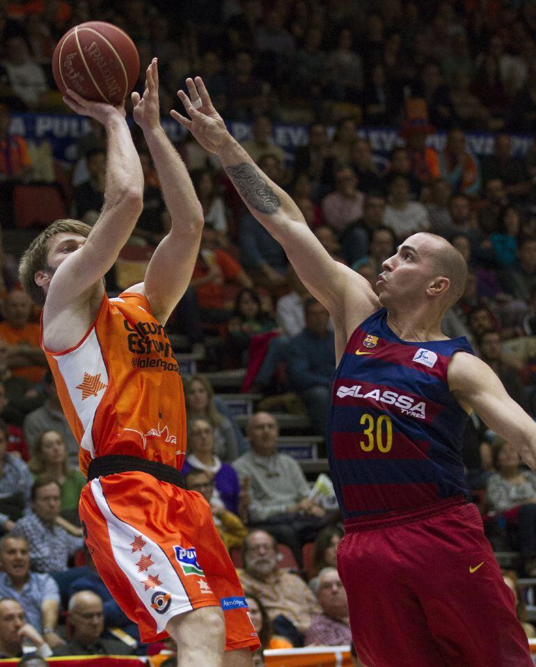 El escolta islandés del Valencia Basket Jon Stefansson (i) lanza a canasta ante la defensa del base Carlos Arroyo, dle FC Barcelona Lassa, durante el partido de Liga ACB que se juega esta tarde en el pabellón Fuente de San Luis, en Valencia.