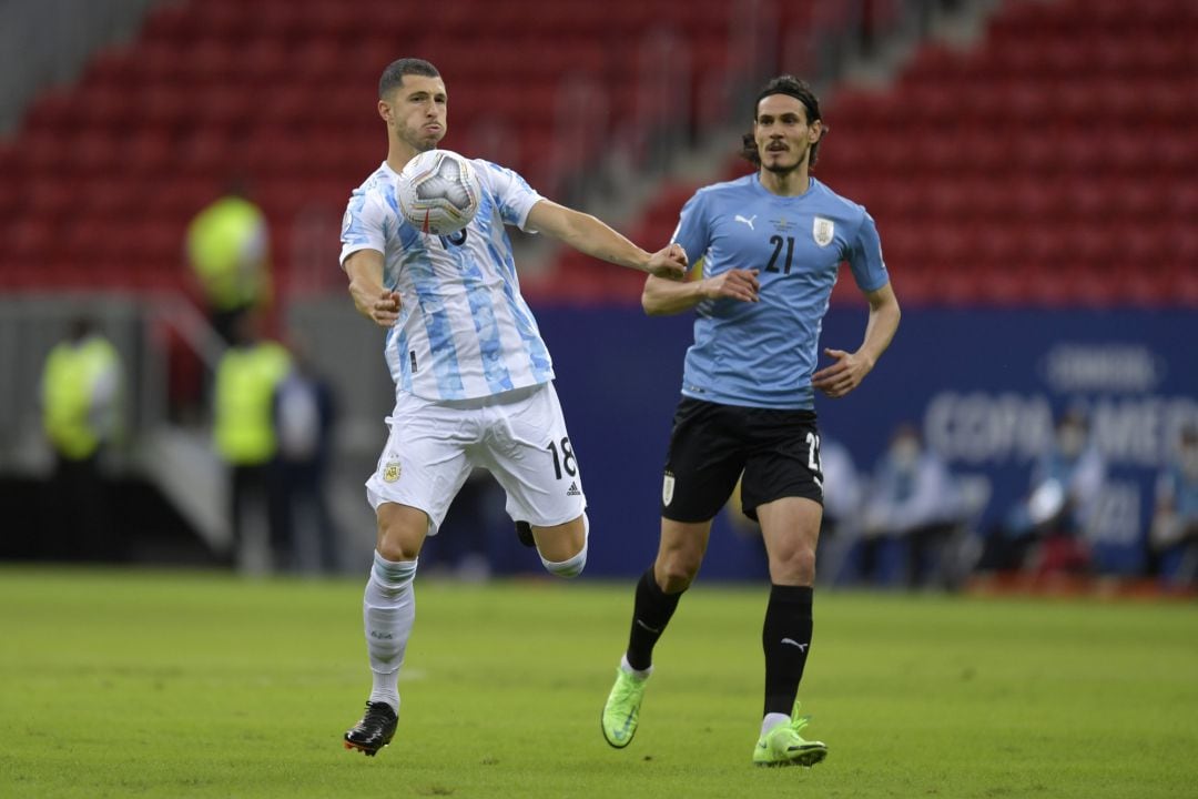 El futbolista del Betis, Guido Rodríguez, controla un balón en presencia del uruguayo Cavani en partido correspondiente a la Copa América. 