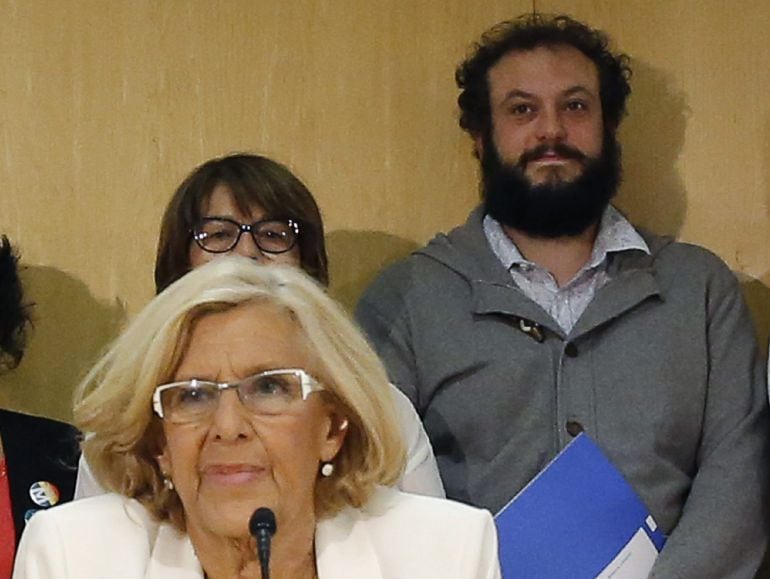 GRA182. MADRID, 15/06/2015.- Fotografía de archivo, del 13/06/2015, de la alcaldesa de Madrid, Manuel Carmena, y el concejal del Área de Cultura y Deportes de Madrid, Guillermo Zapata (d, atrás), durante la rueda prensa ofrecida tras la primera Junta de Gobierno. Zapata comparecerá esta tarde para desvelar su futuro en el Ayuntamiento tras haber sido aceptada su dimisión por Carmena después de la polémica generada por sus tuits ofensivos. EFE/Archivo/Alberto Martín