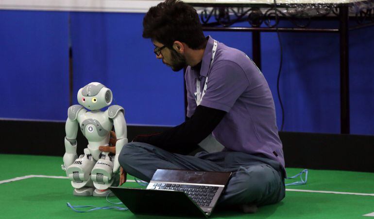 Un estudiante iraní chequea un robot durante la Robocup Irán 2015.