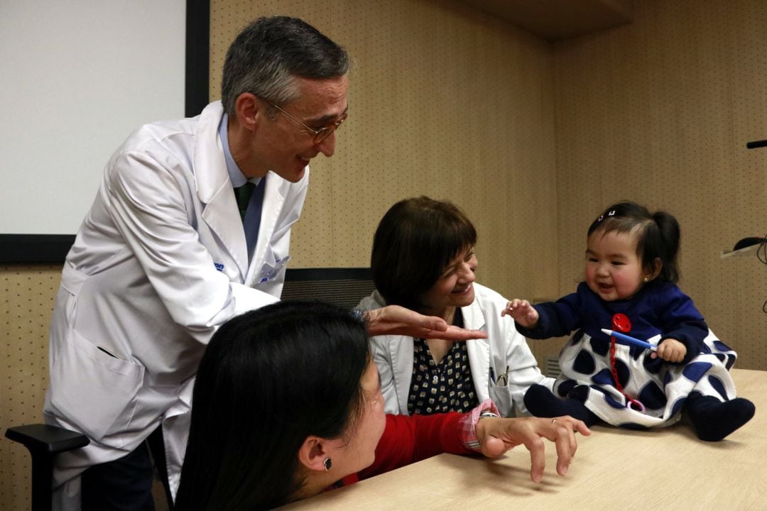 Beatriz, afectada por atrofia muscular espinal infantil juega con su madre y los doctores Francina Munell y Alfons Macaya.