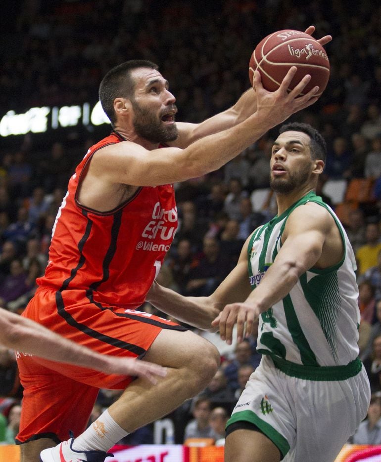 El alero del Valencia Basket, Fernando San Emeterio (i), intenta el lanzamiento ante el alero estadounidense del Real Betis Energía Plus, Trent Lockett (d), durante el partido correspondiente a la décima jornada de la Liga ACB que los dos equipos disputan