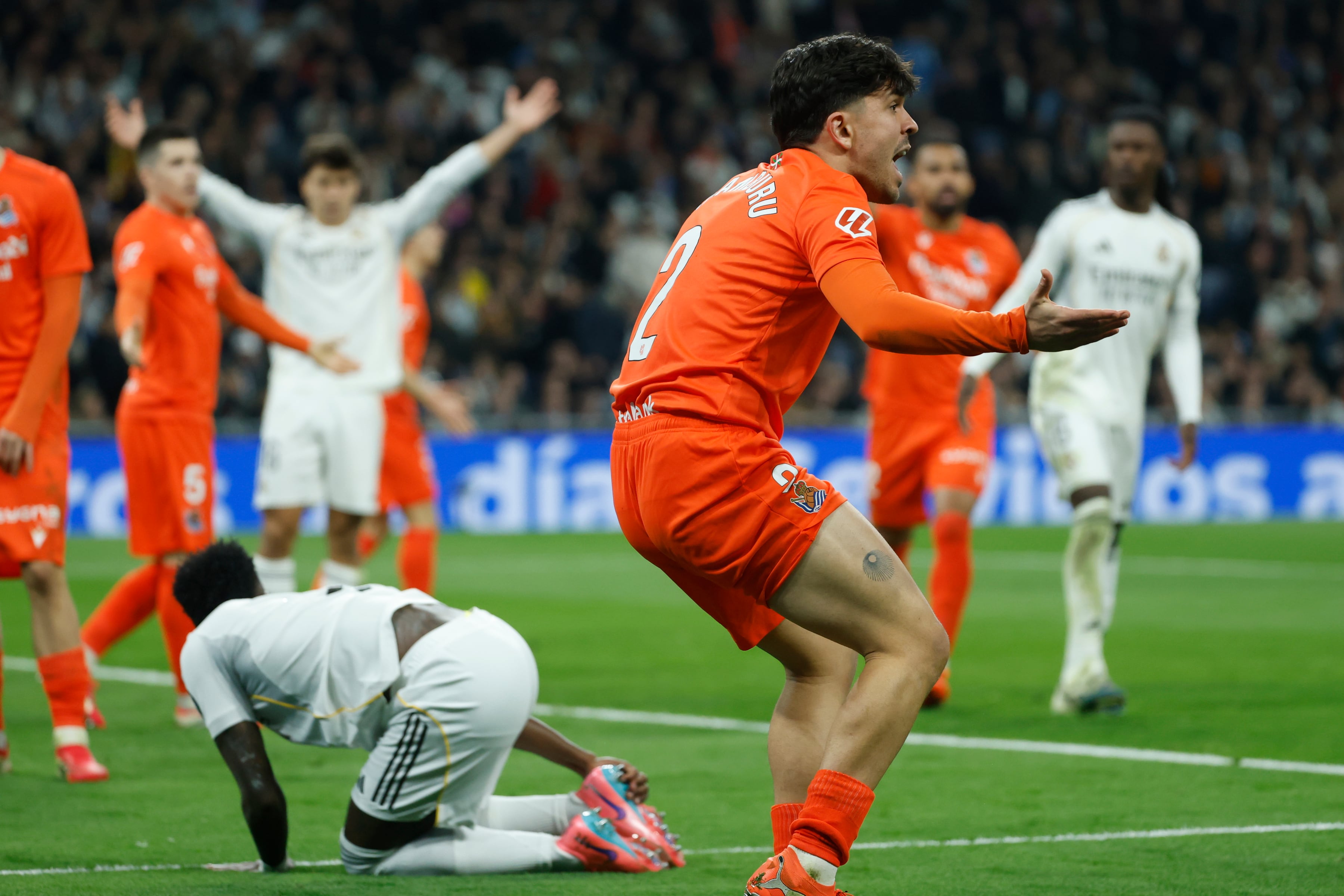 MADRID , 14/02/2026.- El defensa de la Real Sociedad Jon Aramburu (d) protesta la señalización del segundo penalti a favor del Real Madrid en el partido de LaLiga entre el Real Madrid y la Real Sociedad, este sábado en el estadio Santiago Bernabéu. EFE/ JuanJo Martín