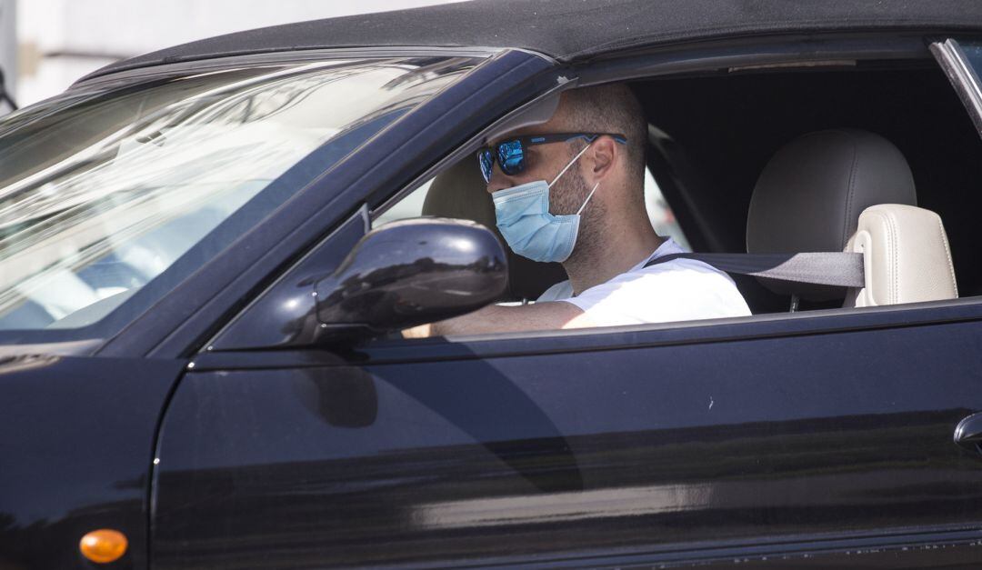 Un conductor con mascarilla circula con su vehículo.