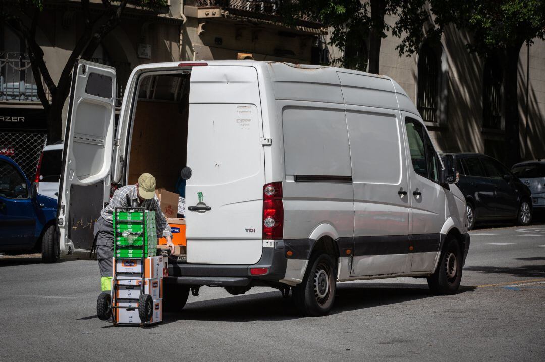 Un repartidor descarga el material de una furgoneta