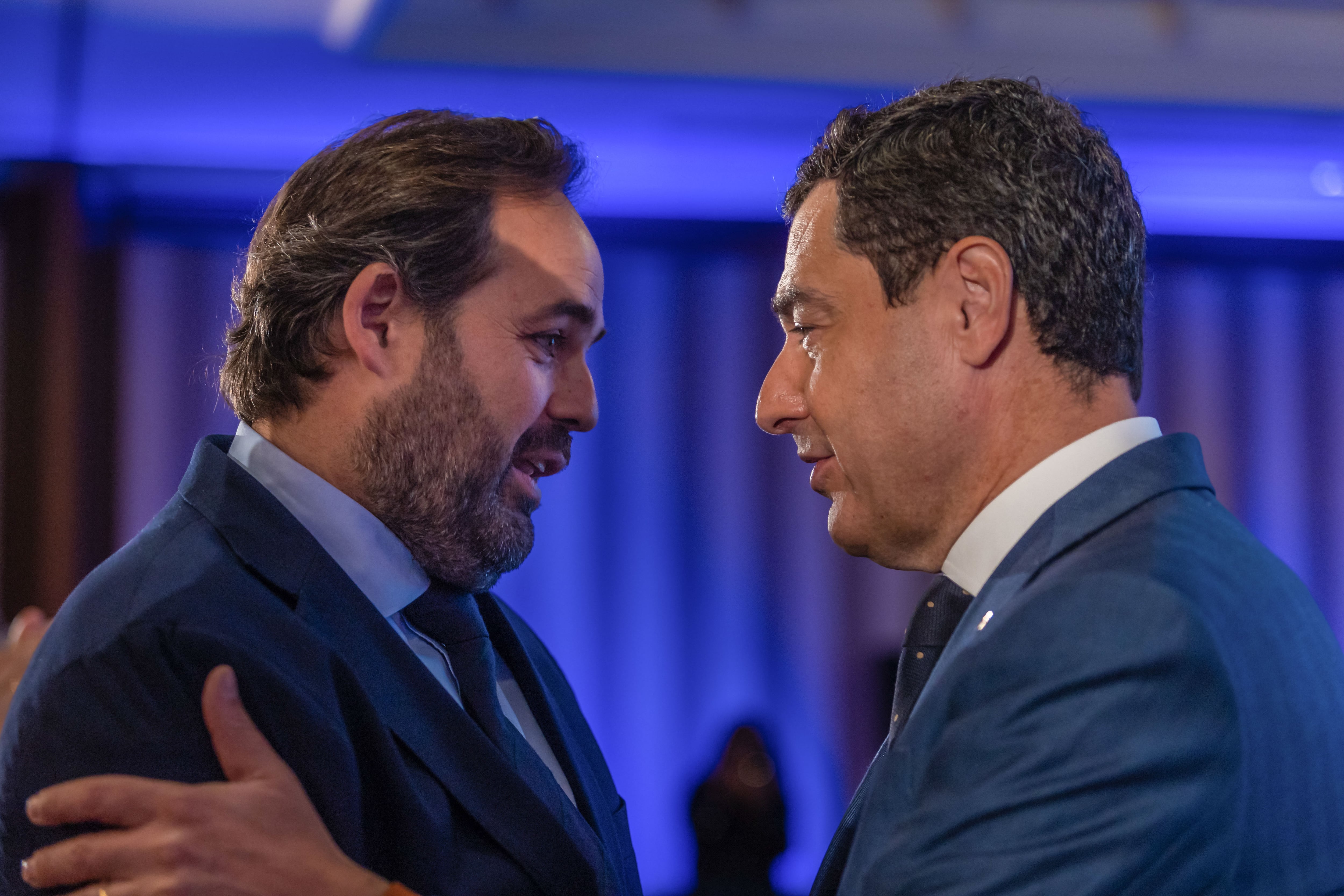 El candidato del PP a la Presidencia de Castilla-La Mancha, Paco Núñez (i), conversa con el presidente de la Junta de Andalucía, Juanma Moreno (d), este sábado en Toledo