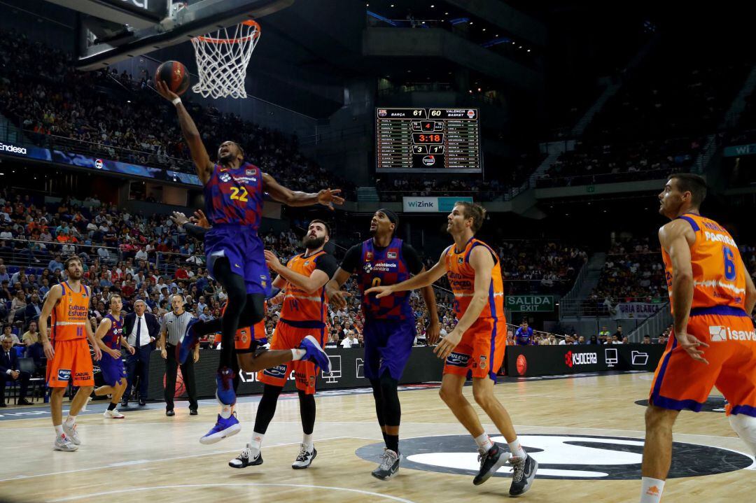 El escolta estadounidense del Barça Cory Higgins entra a canasta junto al montenegrino Bojan Dubljevic, del Valencia Basket, durante la primera semifinal de la Supercopa 