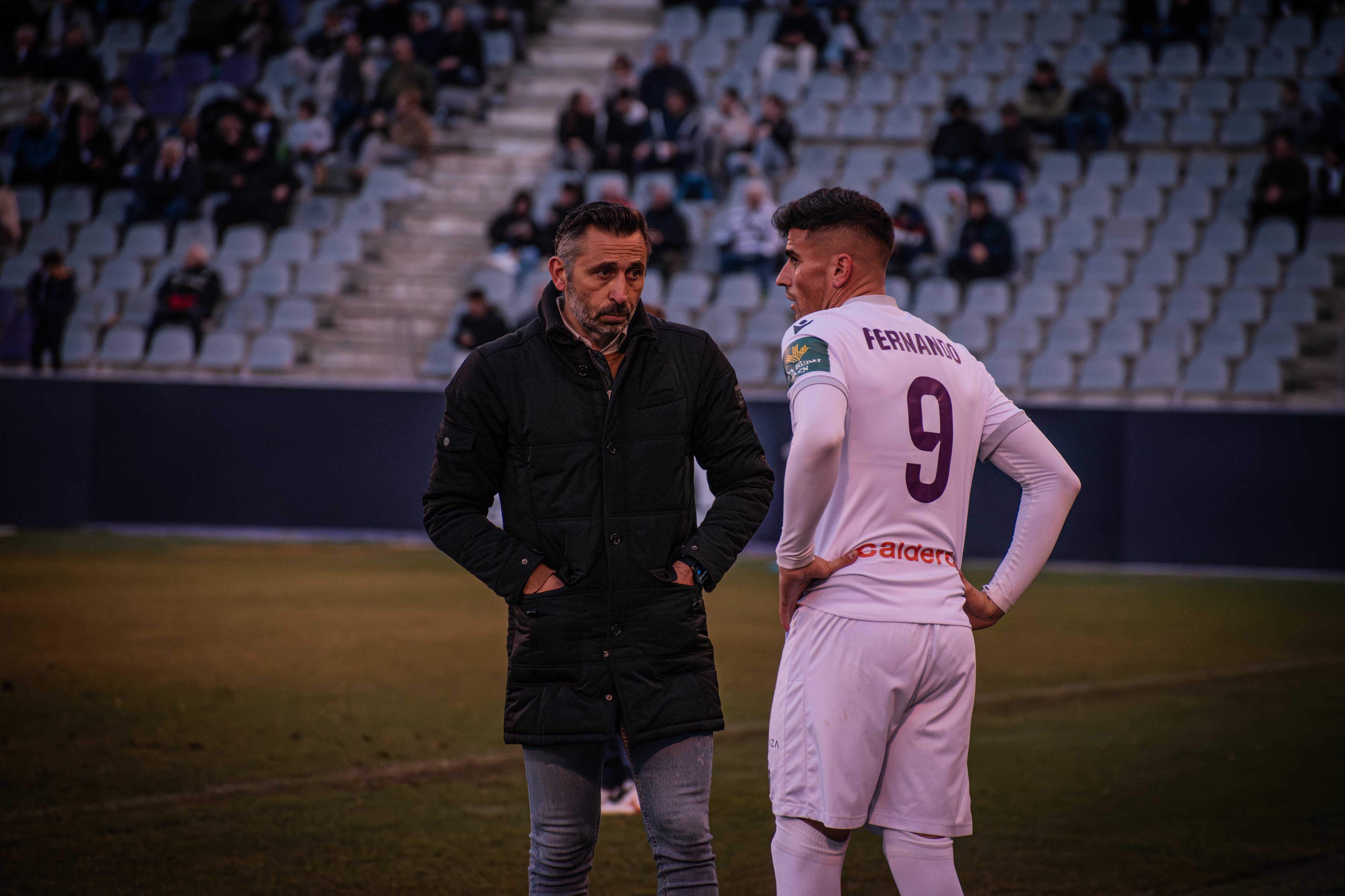 Manolo Herrero conversa con Fernando, jugador del Real Jaén.