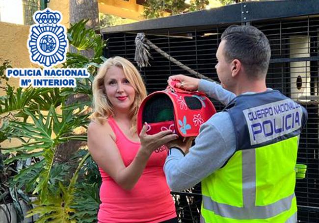 Un agente entrega el loro a su propietaria en un transportín / CNP