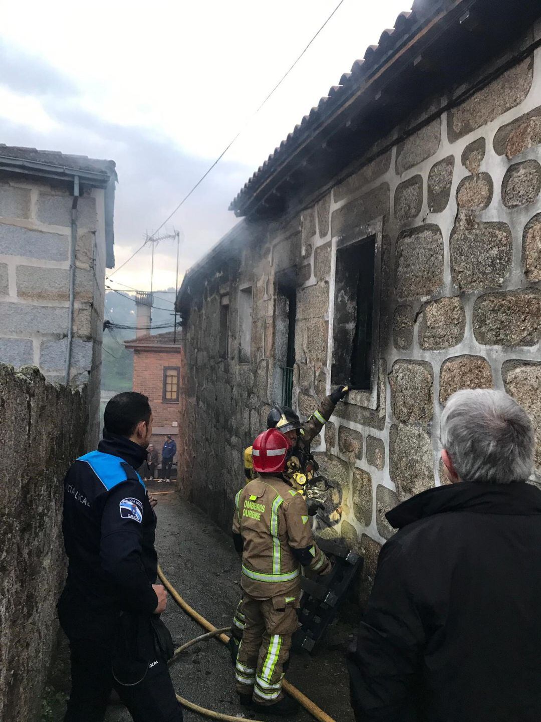 En la imagen dos bomberos supervisan el estado de la vivienda ante la presencia de un policía local y del concejal de infraestructuras