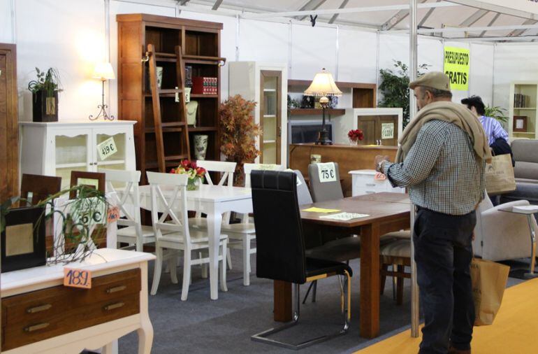 Varias personas observan los muebles expuestos en uno de los stands de la Feria Comarcal de Cuéllar que ayer cerró sus puertas