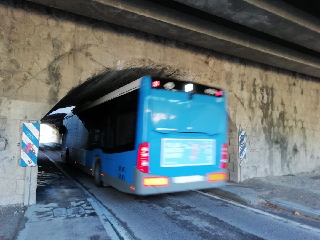 Un autobues de la EMT pasa por  el túnel debajo de las vías del tren y de la M-30 al final de la Calle Embajadores