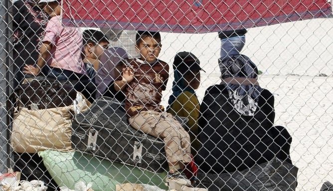 Un grupo de refugiados sirios espera un autobús para devolverlos a su país de origen en un campo de refugiados de Jordania