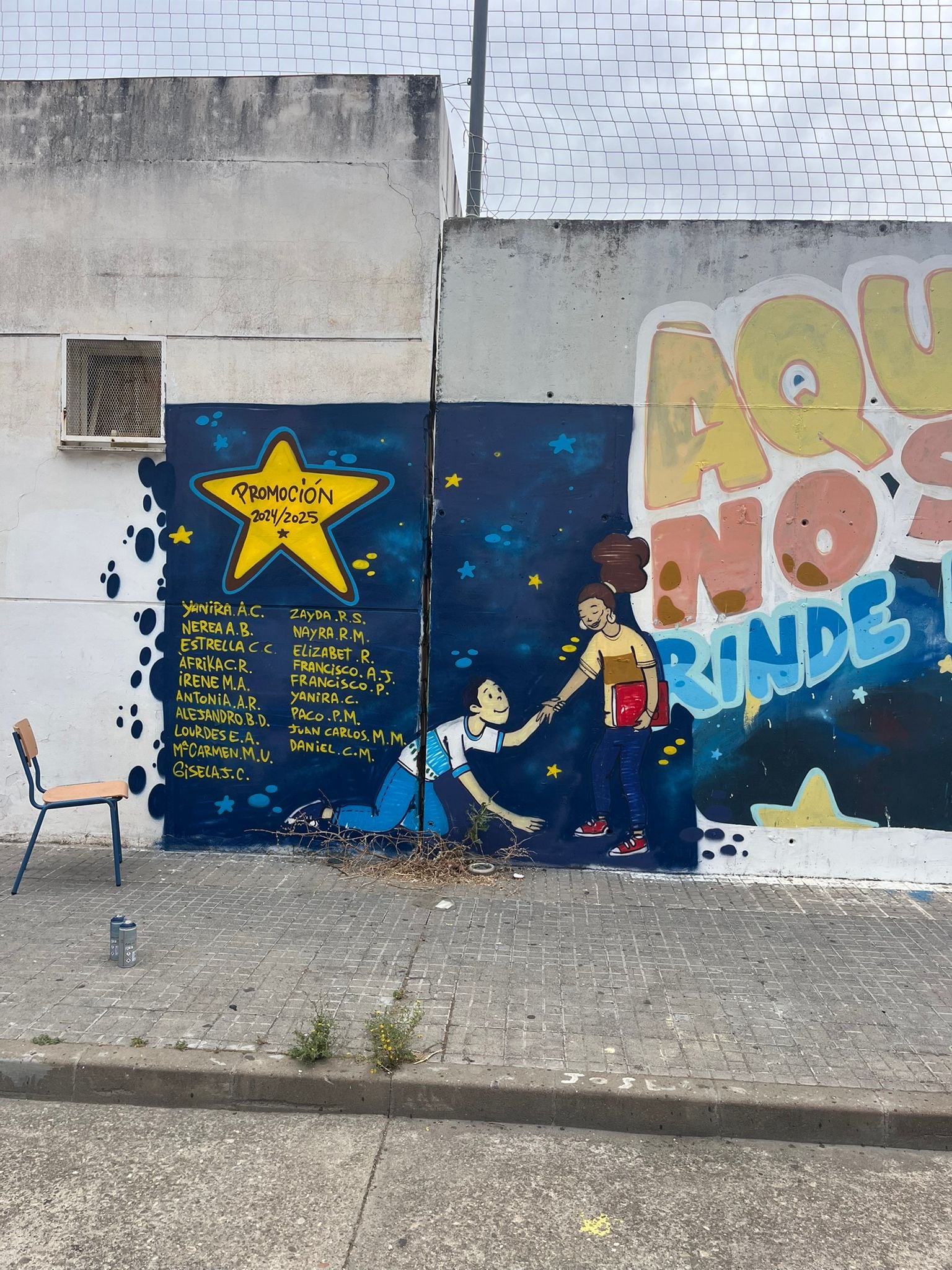 Mural del campo de fútbol de Las Palmeras (Córdoba) con los nombres de las alumnas y alumnos que han conseguido la titulación de la ESO en el curso 2024/2025
