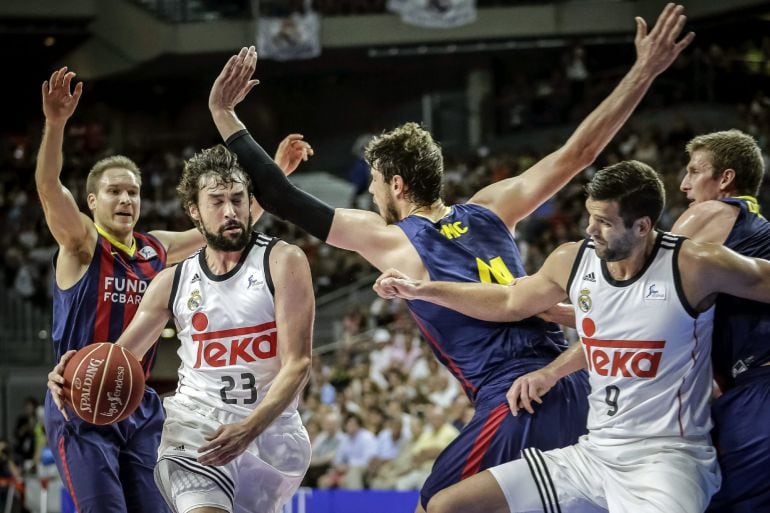 Sergio Llull (2i) con el balón ante la defensa del FC Barcelona durante el segundo partido de la final de la Liga Endesa